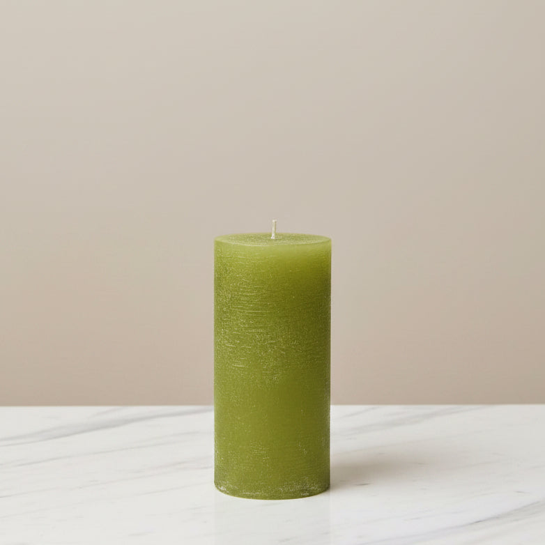 Green candle on a white surface