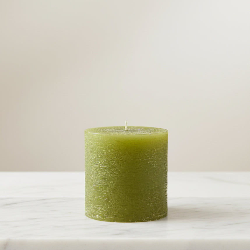 Green candle on a white surface 