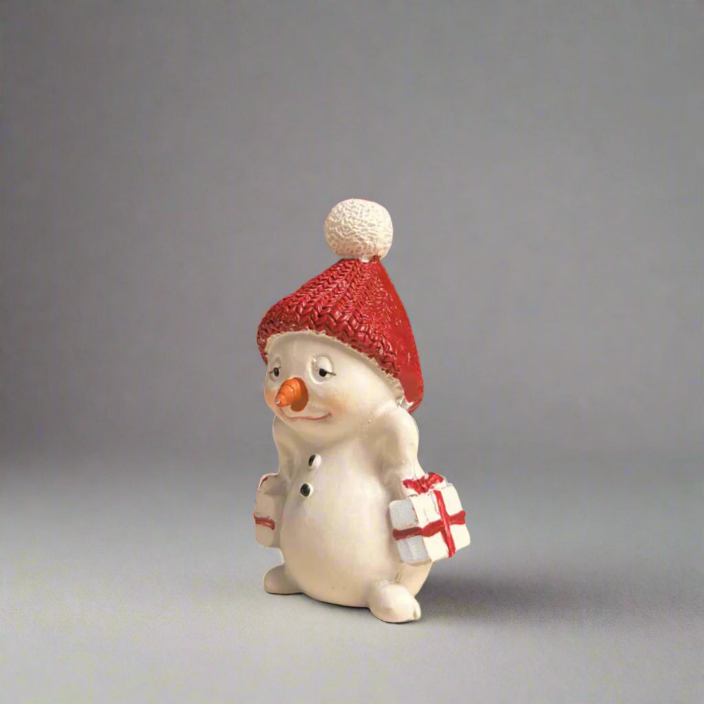 Small snowman figurine with a red beanie and gifts