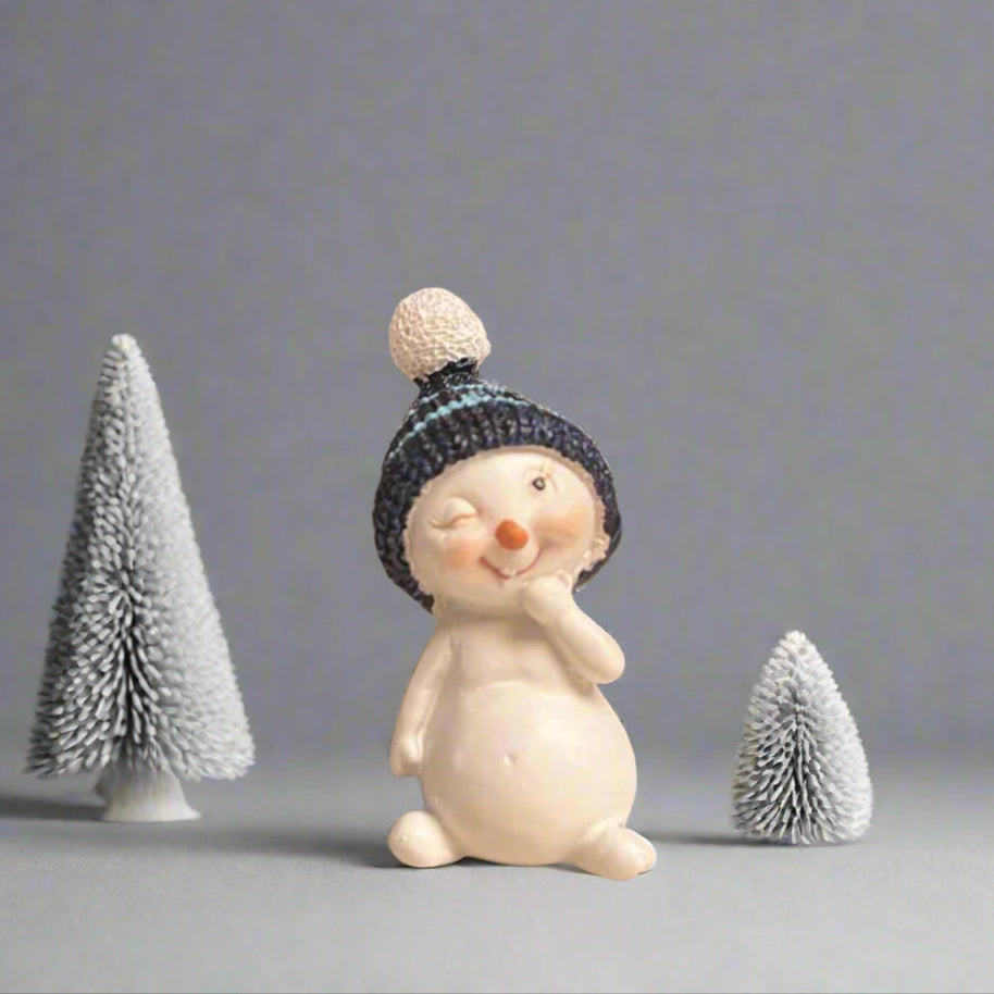 Small snowman figurine wearing a blue beanie