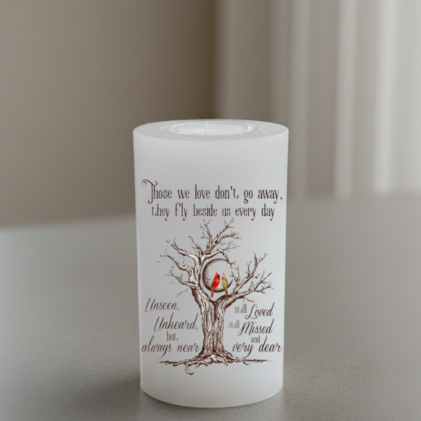 everlasting candle with a tree and birds design and text on a neutral background