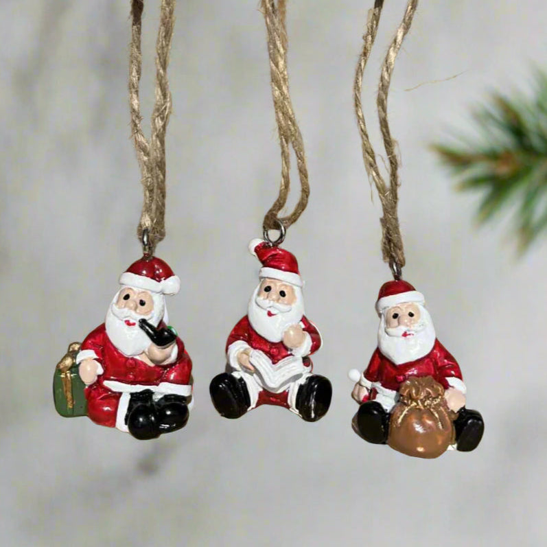 Three small Santa Claus figurines hanging 