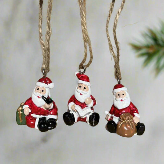 Three small Santa Claus figurines hanging 