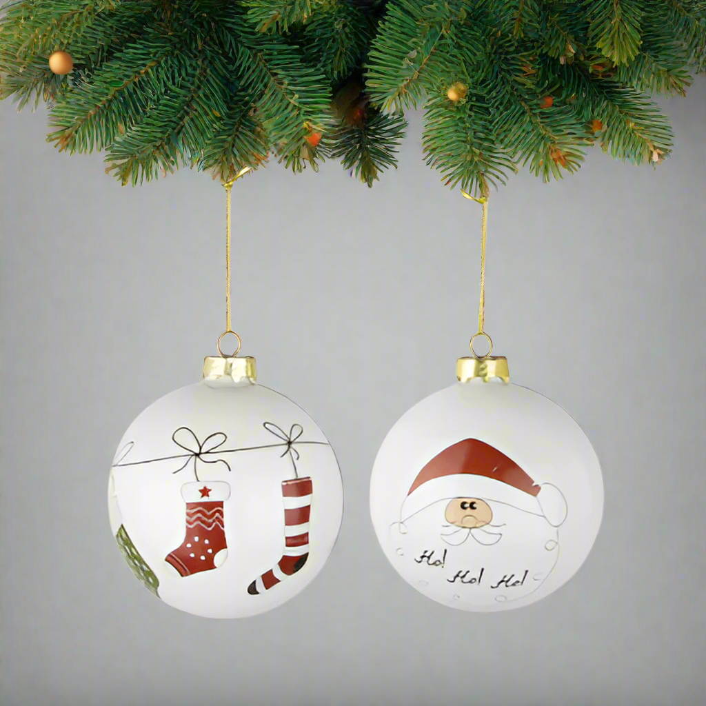 Two Christmas-themed ornaments with stockings and Santa Claus design hanging on a branch of fir