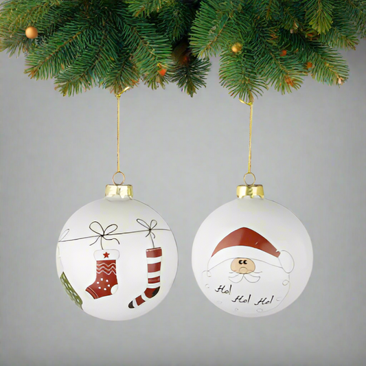 Two Christmas-themed ornaments with stockings and Santa Claus design hanging on a branch of fir