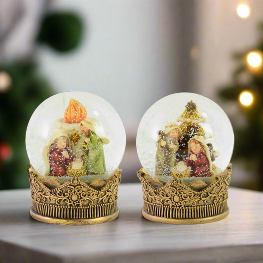 Two decorative snow globes with nativity scenes in a festive room