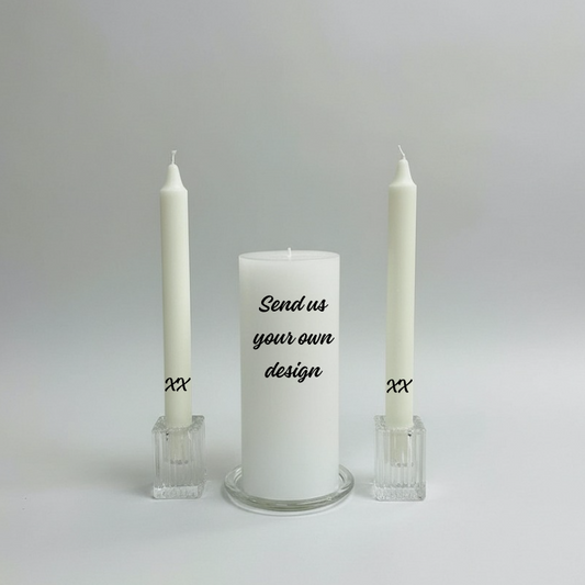 White candle with text and two white candles in holders on a light gray background