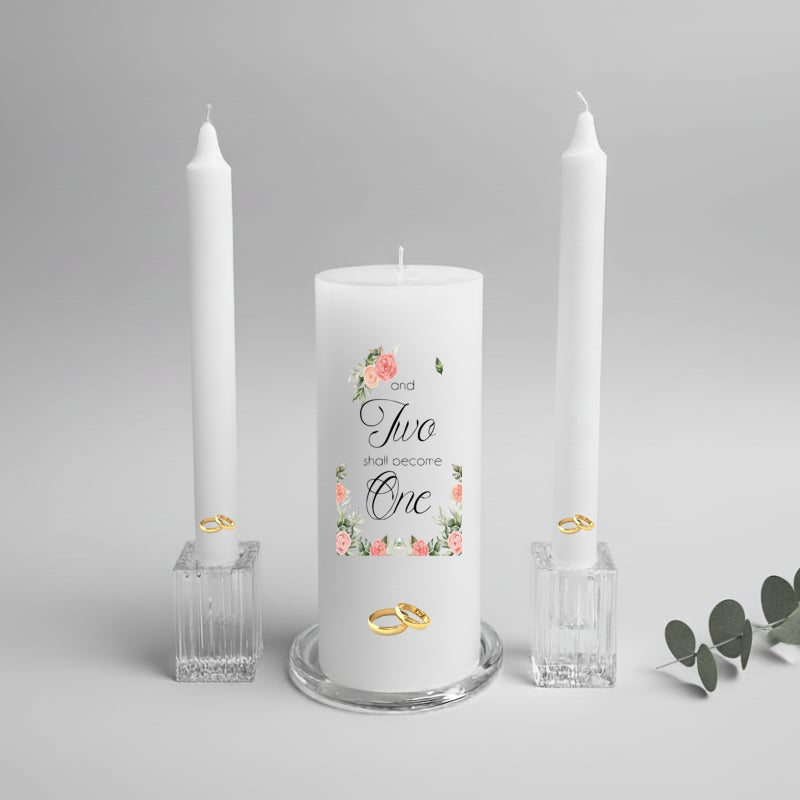 Wedding unity candle with floral design and text, flanked by two white dinner candles on a gray background.
