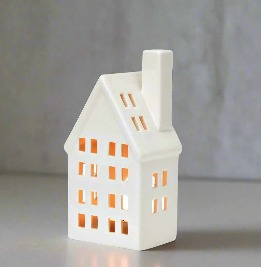 White house-shaped porcelain lantern with small windows on grey background