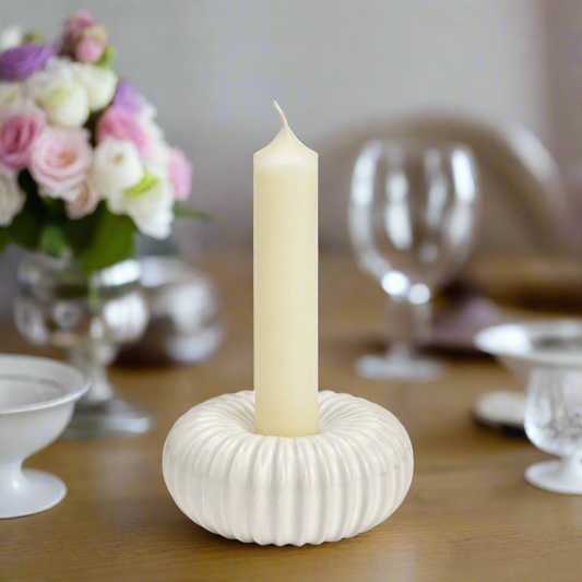 White porcelain candle holder with a dinner candle 