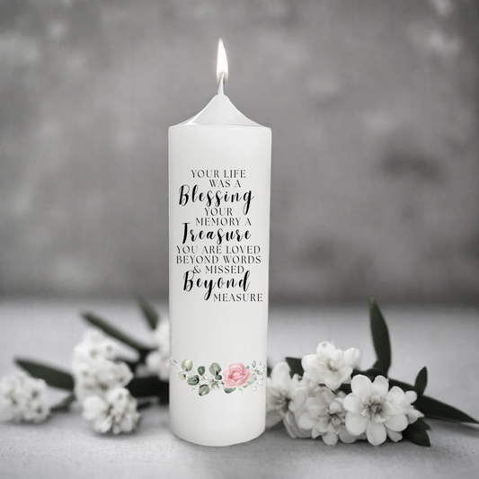 White memory candle with text and floral design on a gray background