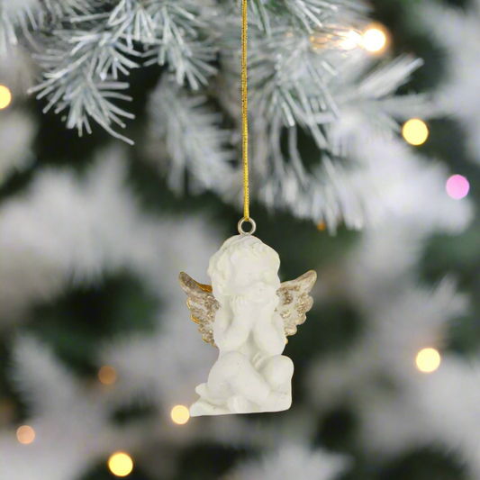 White angel figurine ornament with gold wings on a christmas tree