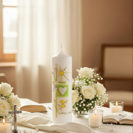 Decorative baptism candle with religious symbols on a table with flowers and candles.