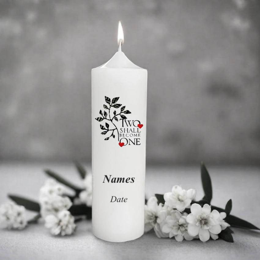 White wedding candle with 'Two Shall Become One' design and floral elements on a gray background