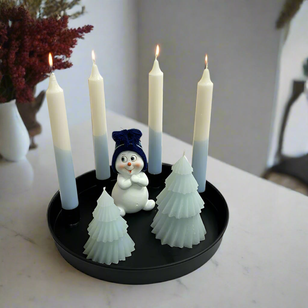 black tray with 4 magnet dinner candle holders and candles and winter scenery with 2 trees and a snowman