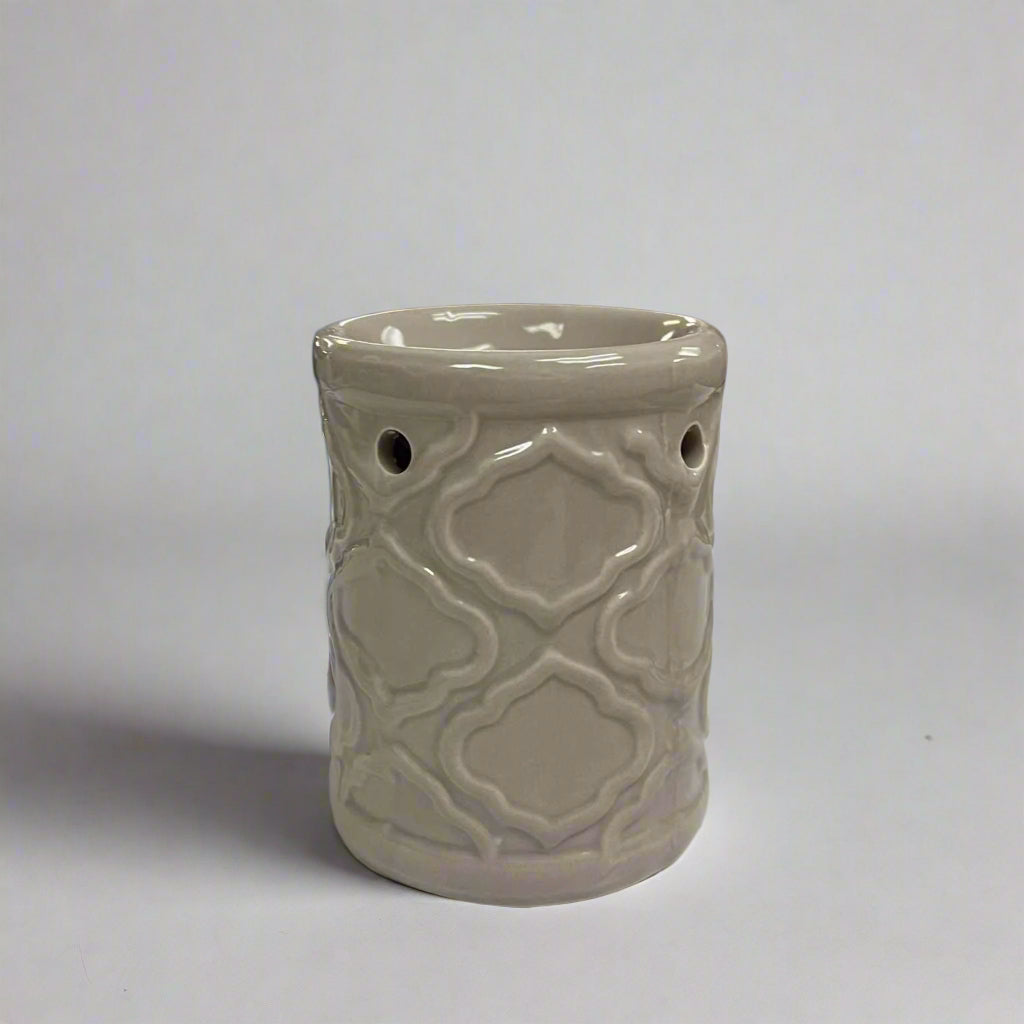 Decorative ceramic burner with intricate patterns on a neutral background.