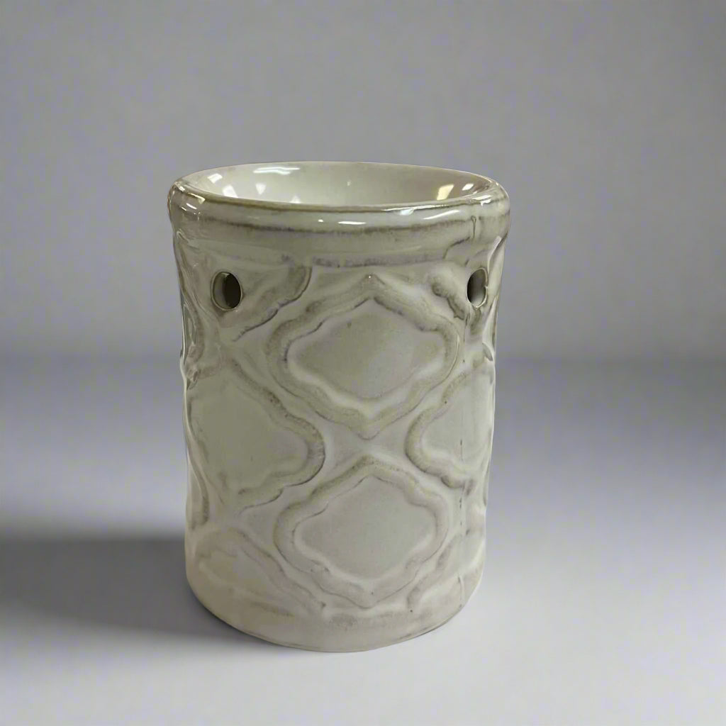 White ceramic burner with geometric pattern on a neutral background