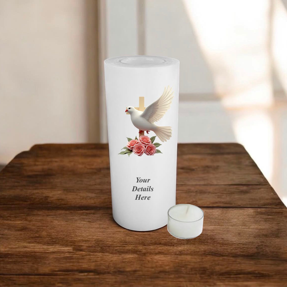 White candle with a dove and roses design on a wooden surface