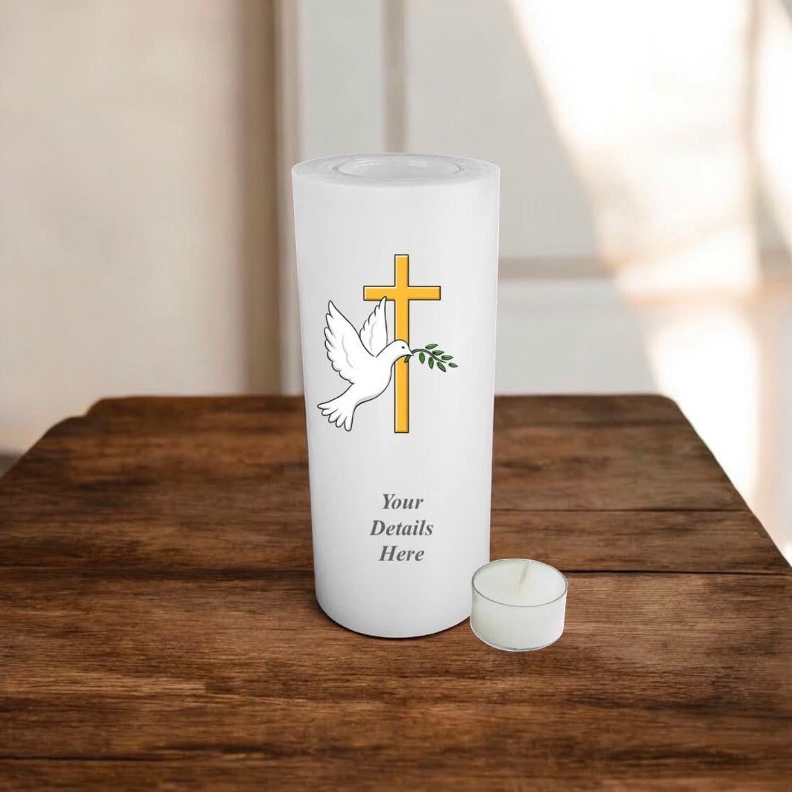 A white candle with cross, dove, and olive branch design on a wooden surface.