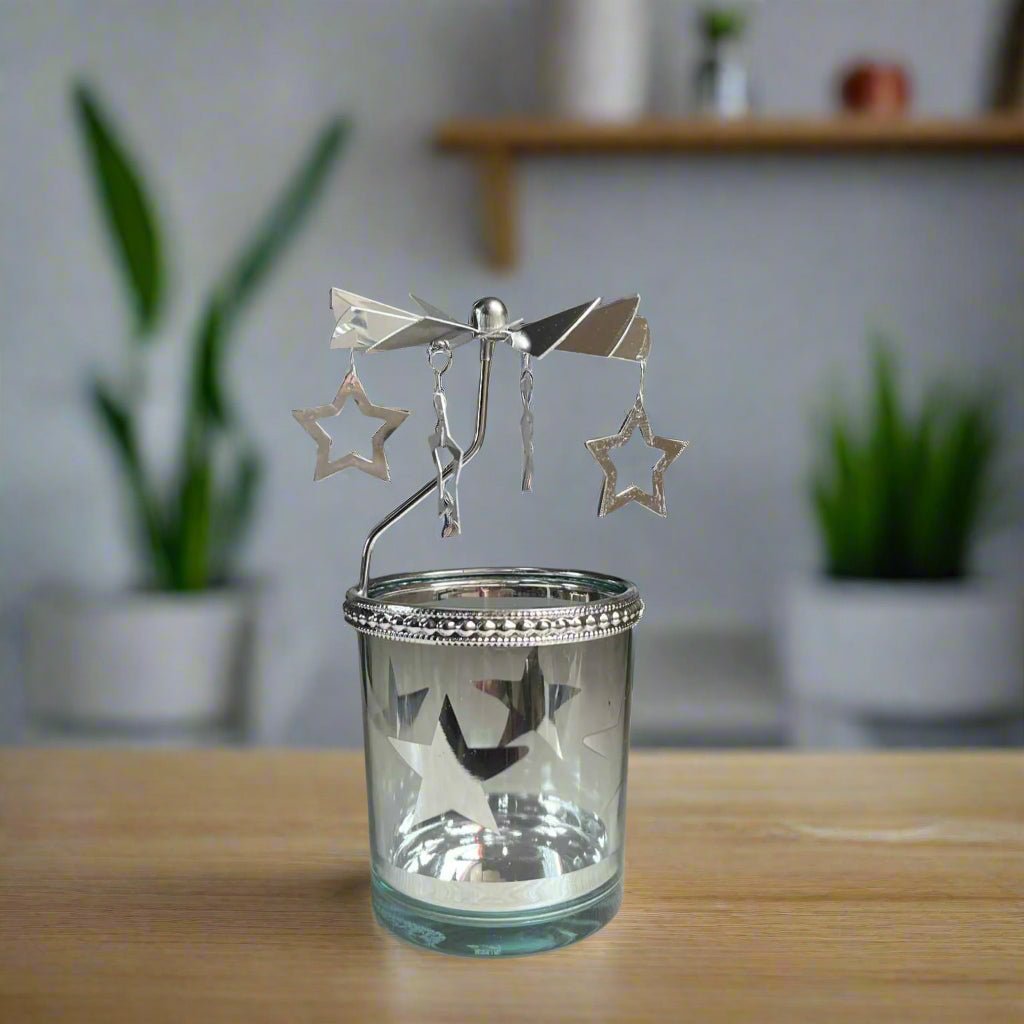 Glass candle holder with star-shaped ornaments on a table