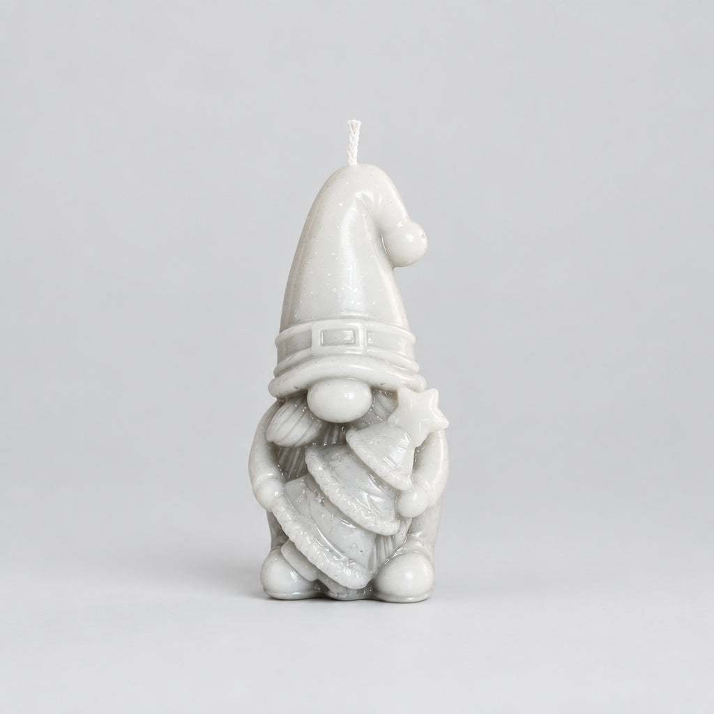 A Christmas gnome candle holding a tree