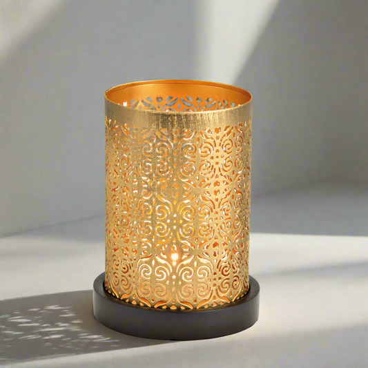 Decorative gold candle lantern holder with intricate patterns on a grey background
