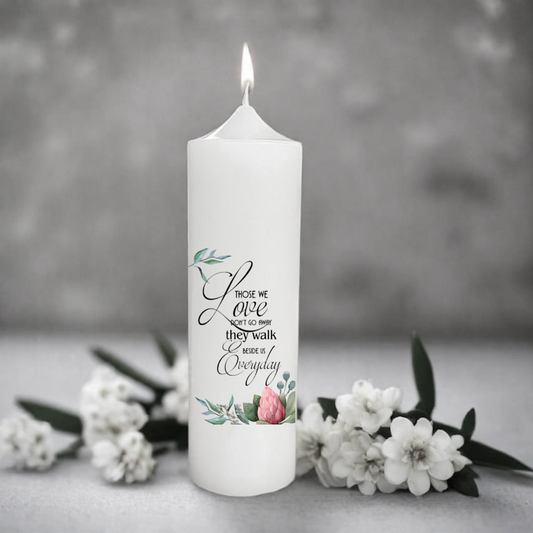 White memory candle with floral design and text on a gray background