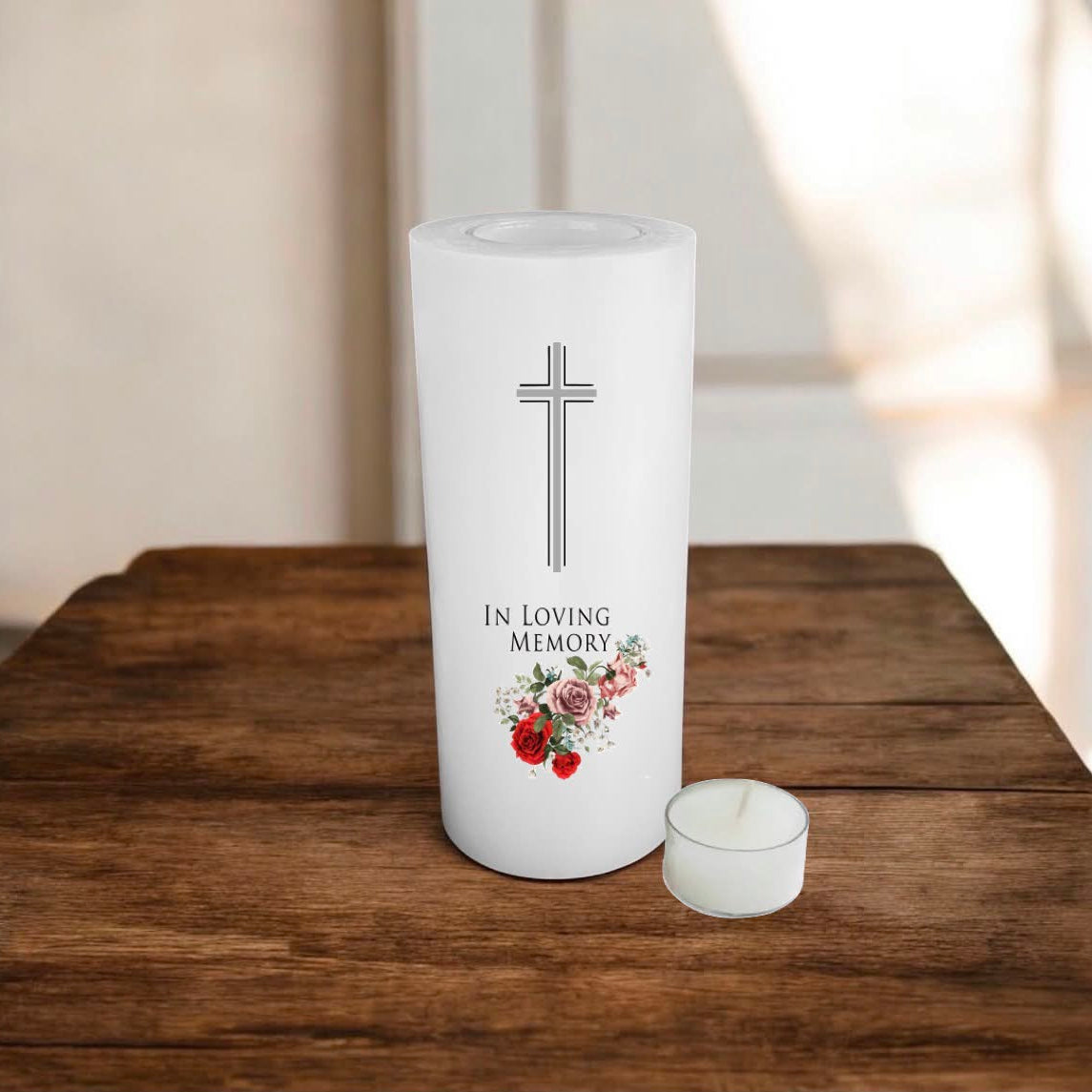 White candle printed with a cross, text and roses, placed on a wooden surface
