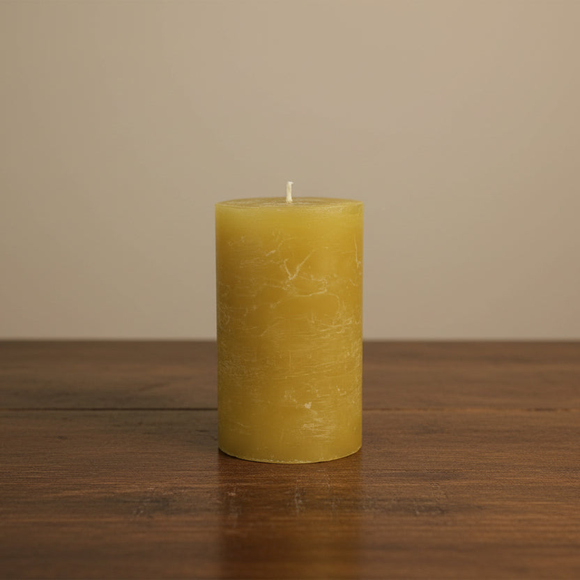 mustard candle on a brown surface 