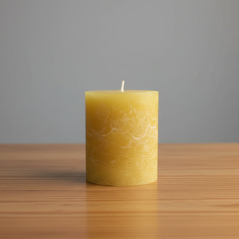 mustard rustic candle on a brown surface 