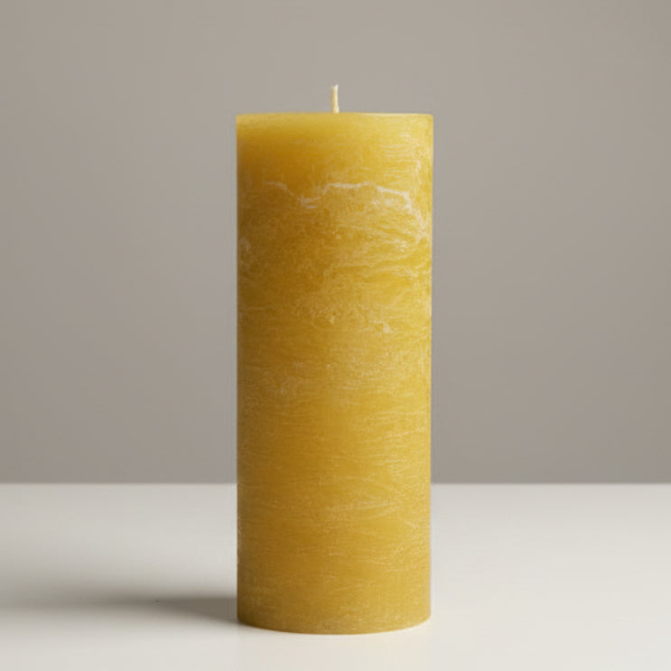 mustard rustic candle on a white surface 