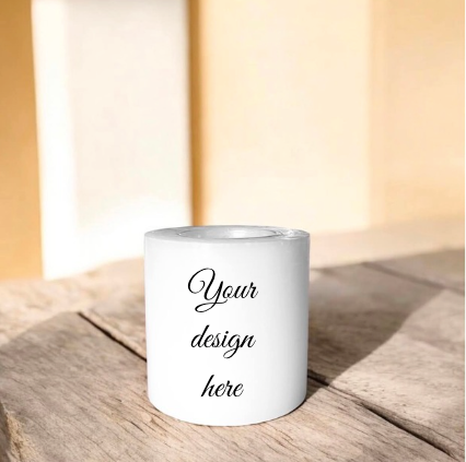 A white candle black text reading 'Your design here', placed on a rustic wooden surface.