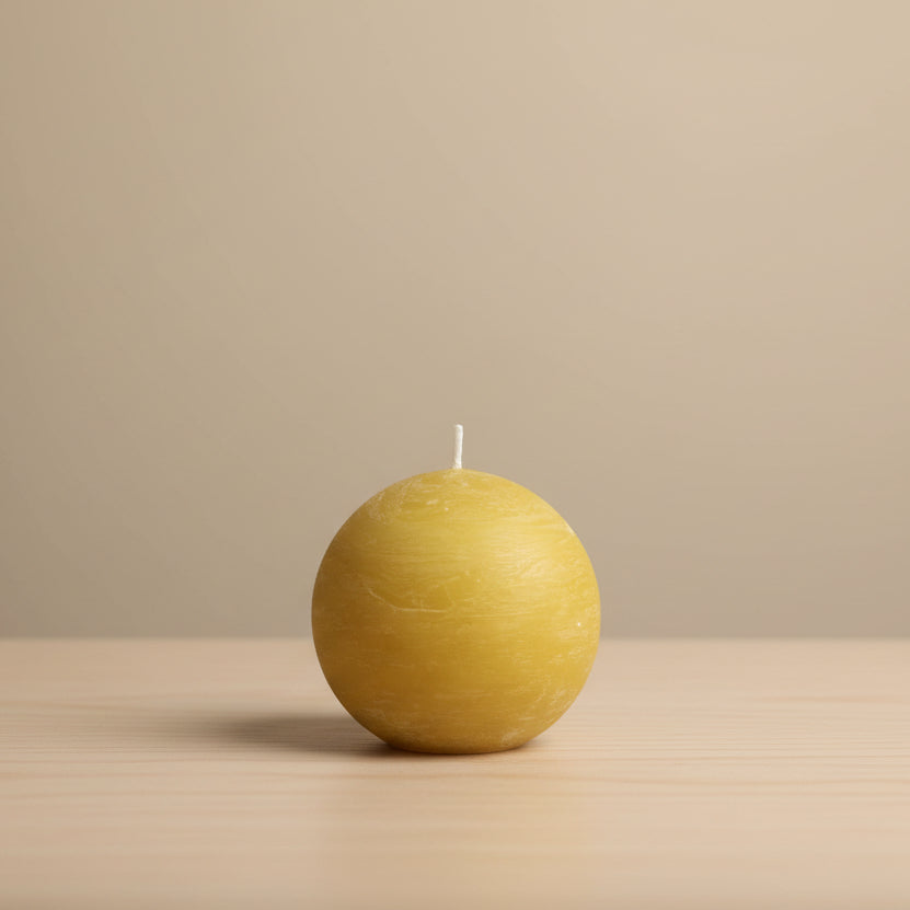mustard spherical candle on a surface