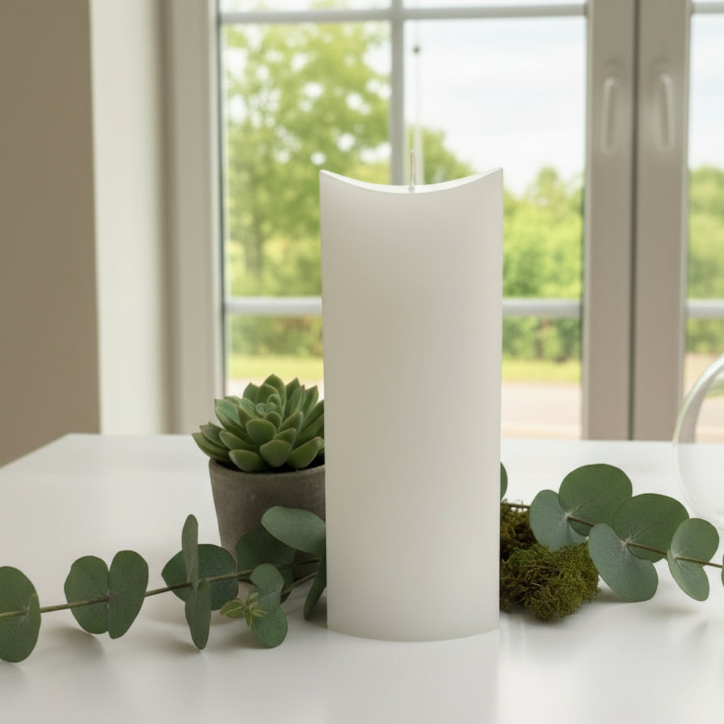 White candle on a white surface with a window in background