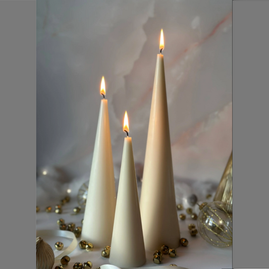 three beige cone candles with gold decoration around