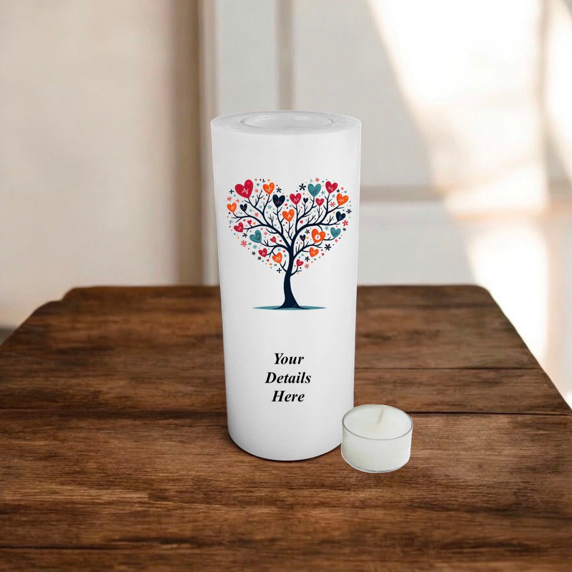 White candle with a decorative tree design on a wooden surface