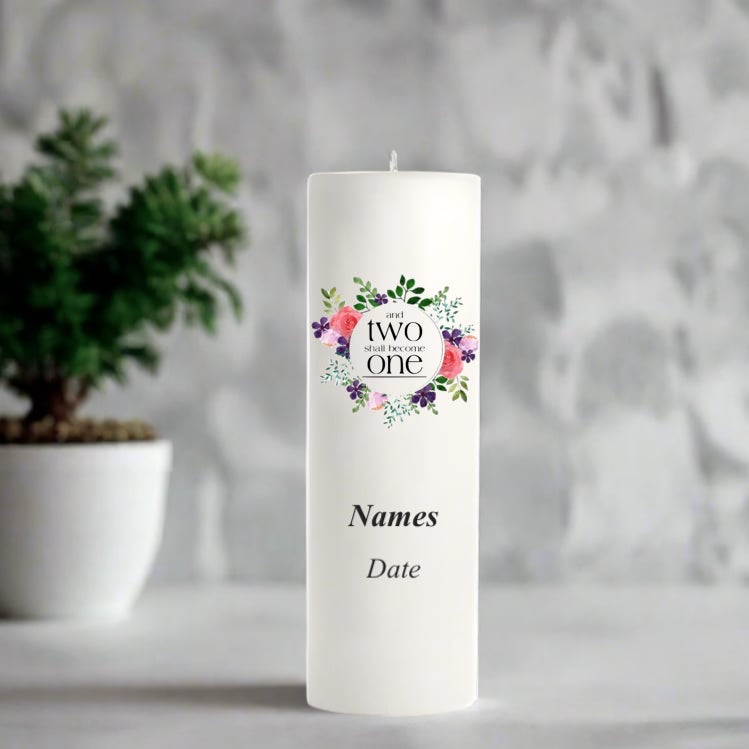 White candle with floral design and text in a decorative setting