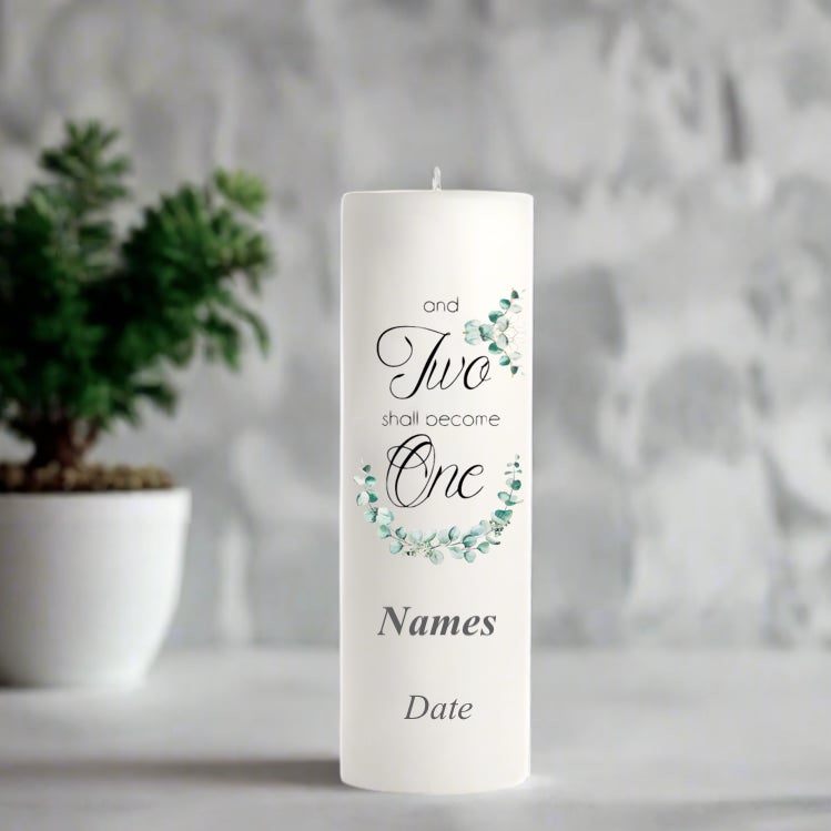 White wedding candle with decorative text and floral design on a blurred background