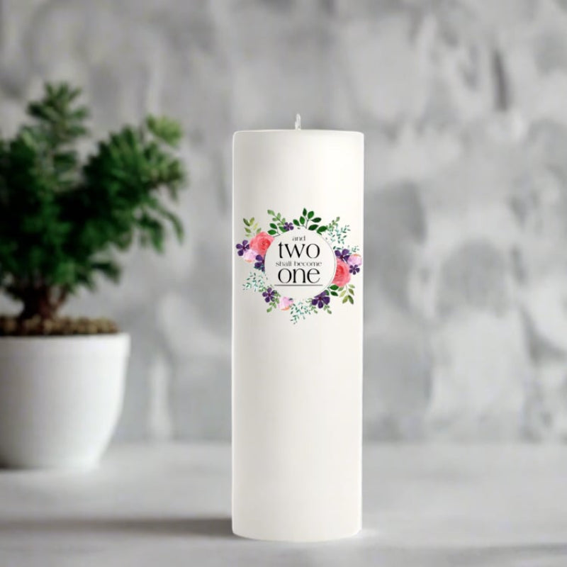 White wedding candle with floral design and text in a decorative setting